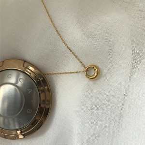 Detailed close-up of a minimalist gold hollow circle pendant on a fine O-link chain