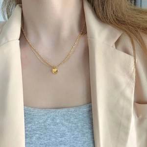 Double-layered gold heart pendant necklace with beaded chain for a vintage minimalist look