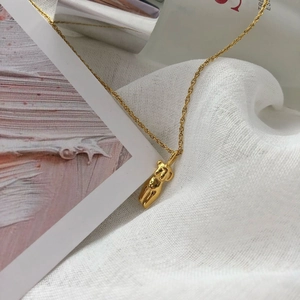 Collier doré artistique avec pendentif silhouette de corps féminin sur fond en lin