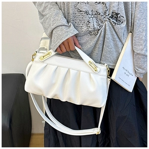 Detail of white pleated cloud bag featuring lychee texture and gold geometric buckle