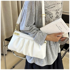 Detail of white pleated faux leather handbag with soft texture and gold clasp buckle