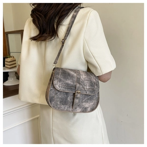 Retro smoky gray saddle bag with matte leather texture and adjustable gold hardware strap