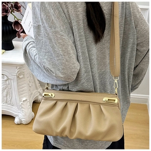 Detail of light beige pleated soft leather handbag with vintage gold metal hardware details