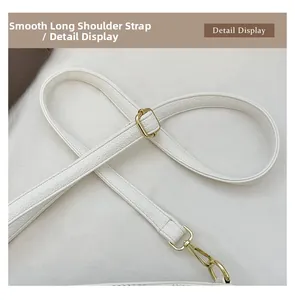 Detail view of smooth adjustable white lychee leather shoulder strap with gold hardware