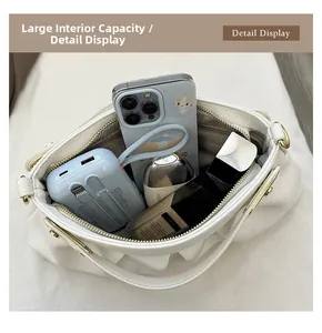 Top view of the spacious interior of a white lychee leather handbag with daily essentials