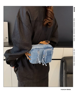 Details von gewaschener Denim-Brusttasche mit Reißverschlüssen und Vintage-Fransen