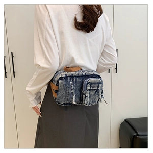 Detail der Vintage-Brusttasche aus Denim an der Taille mit robustem braunem Gurt