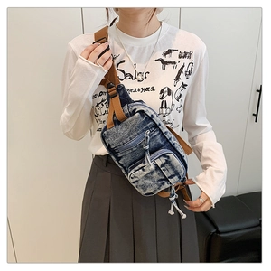 Nahaufnahme der Vintage-Brusttasche aus Denim mit braunen Nylonriemen und zwei Reißverschlüssen