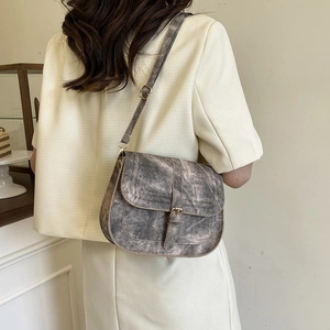 Vintage gray saddle crossbody bag with adjustable strap on model back view