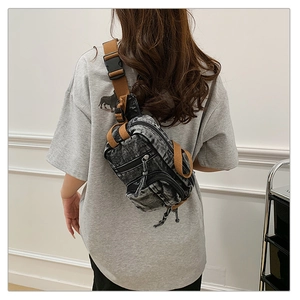 Detailansicht der Brusttasche aus gewaschenem Denim mit dickem Gurt und Reißverschluss