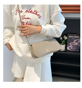Detailed macro view of the beige lychee-patterned leather flap on the shoulder bag