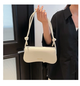 Detail of white lychee-patterned leather underarm bag with gold metal hardware and knot strap