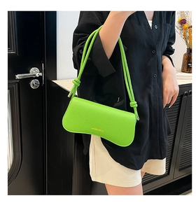 Detail of neon green lychee leather underarm bag with wavy base and thin straps