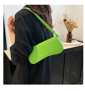 Detail of lime green pebble leather shoulder bag showing the curved shape and brand logo