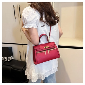 Macro-opname van rode tas met litchi-textuur en luxe goudkleurige metalen hardware
