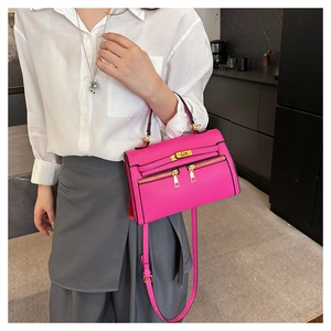 Detailopname van de magenta Kelly-stijl tas met ritsen en goudkleurige metalen details