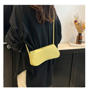 Close-up of yellow lychee grain leather crossbody bag shown on model for style reference