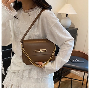 Détail du sac en cuir marron avec boucle en métal doré et chaîne décorative chic