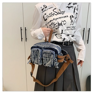 Détail du sac de poitrine en denim délavé avec sangle réglable et deux poches avant