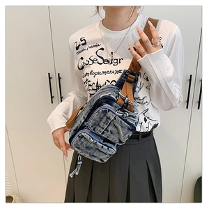 Détail du sac de poitrine en denim vintage avec trois zips et bandoulière marron sur mannequin