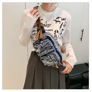 Détail du sac de poitrine en denim délavé vintage avec deux poches zippées à l'avant