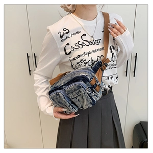 Détail du sac bandoulière en denim bleu vintage avec poches zippées et sangle marron