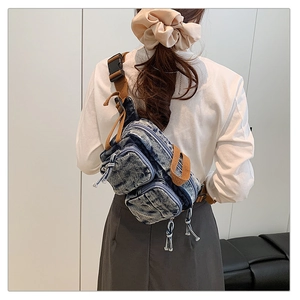 Détail du sac de poitrine en denim vintage avec sangle marron et poches zippées multiples