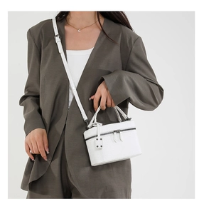 Close-up of white crocodile pattern box bag on model with silver metal hardware detail