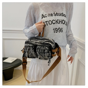 Détail du sac de poitrine en denim délavé avec poches multiples et sangle marron