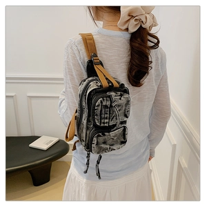 Détail du sac de poitrine en denim gris délavé avec bandoulière tissée style vintage