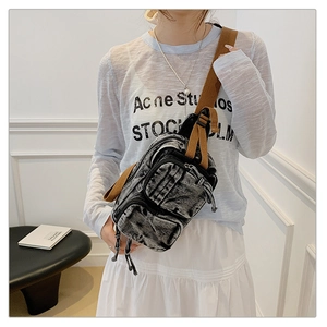 Détail du sac de poitrine en denim vintage avec plusieurs fermetures éclair et sangle
