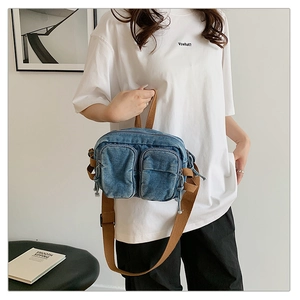 Détail du sac de poitrine en denim vintage avec doubles poches et sangle marron