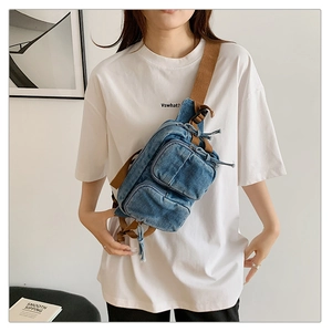 Détail du sac de poitrine en denim bleu clair avec multi-poches et sangle tressée