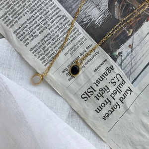 Detail of vintage oval necklaces with black and white agate pendants on gold chains