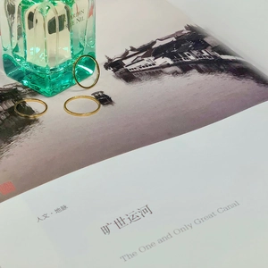 Three minimalist gold thin rings styled with a perfume bottle and an art book