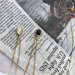 Close-up of vintage oval necklace with black and white agate pendants on gold chain