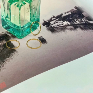 Three minimalist gold slim stacking rings displayed on an artistic background