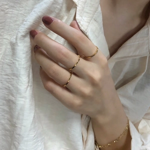 Minimalist gold thin ring set and matching chain bracelet worn with casual style