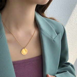 Golden round pendant necklace featuring a Praying Hands relief and ONE DAY AT A TIME text