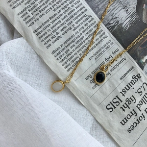 Close-up of vintage gold necklaces with oval black and white agate pendants