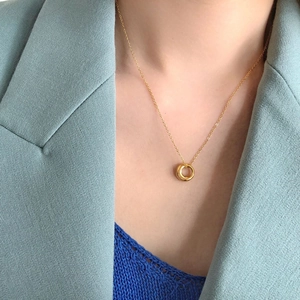 Elegant gold circle pendant necklace on a delicate chain worn by a model in close-up view