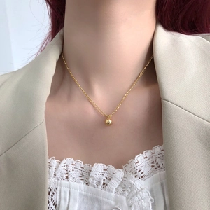 Double-layered gold beaded necklace on model, minimalist stacked ball chain jewelry