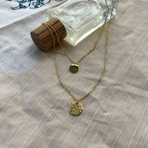 Nahaufnahme der zweilagigen Goldkette mit glatten und gehämmerten runden Anhängern im Set