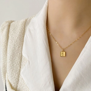 Gros plan détaillé du collier pendentif carré gravé d'une rose sur un mannequin