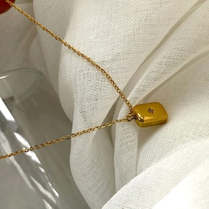 Elegant gold titanium necklace with a rectangular star pendant on a delicate chain