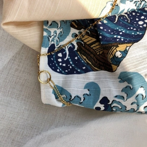 Close-up of golden metal chain on fabric with Great Wave off Kanagawa art print