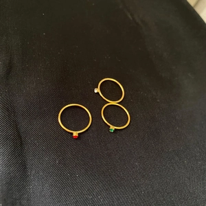 Macro shot of 14k gold-plated minimalist rings with red, green, and clear gemstones