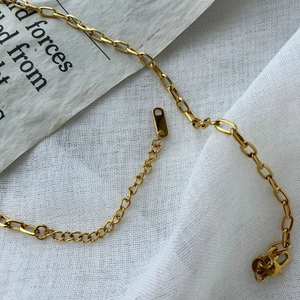 Macro detail of golden oval link necklace with secure lobster clasp and extension chain