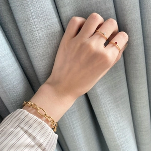 Detail of 14k gold plated ring set with red crystal and chunky link chain bracelet