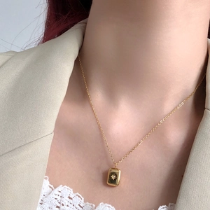 Macro shot of gold-plated titanium steel necklace with rectangular starburst pendant
